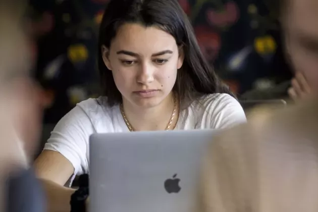 Ung kvinna framför en dator.