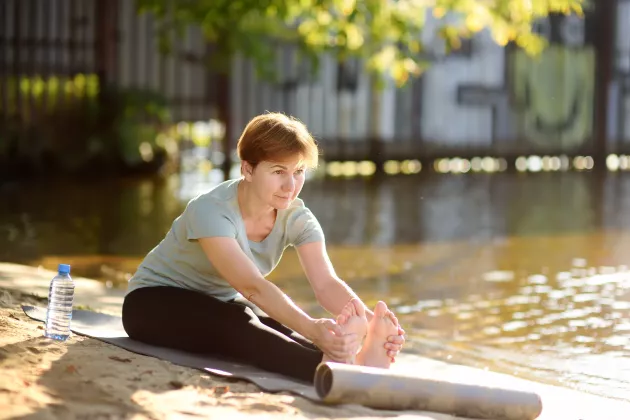 A woman sitting by a lake.