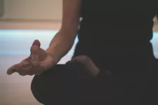 En kvinna i yogaställning, sittande, beskuren. Unsplash.