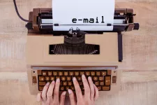 Ett par händer skriver "e-mail" på en skrivmaskin. Mostphotos.