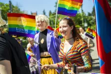 Två personer med regnbågsfärger i paraden.