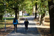 Två personer cyklar i Slottsparken.